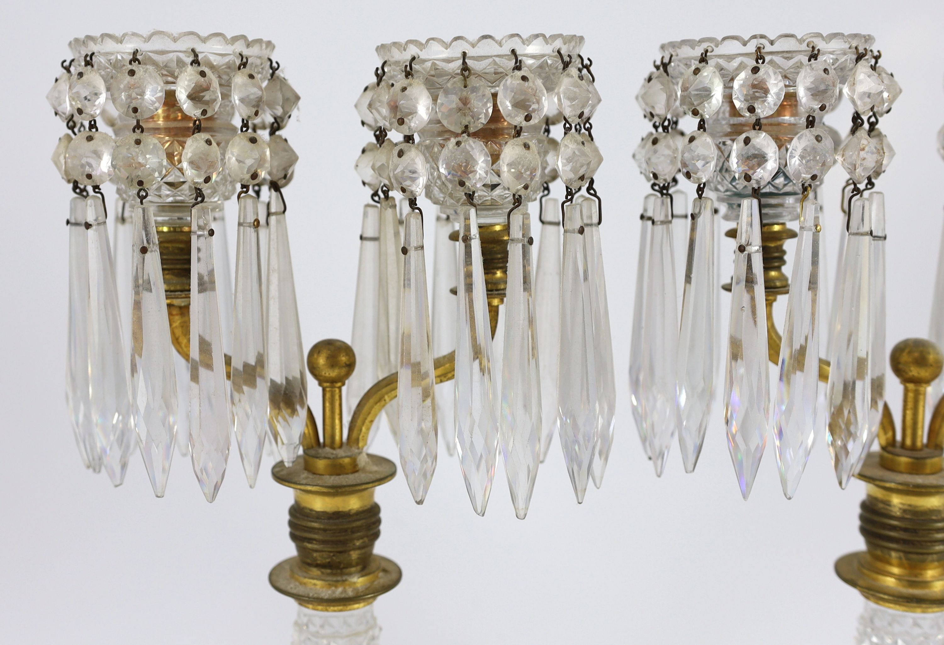 A pair of Regency ormolu and cut glass two branch candelabra, 33cm high